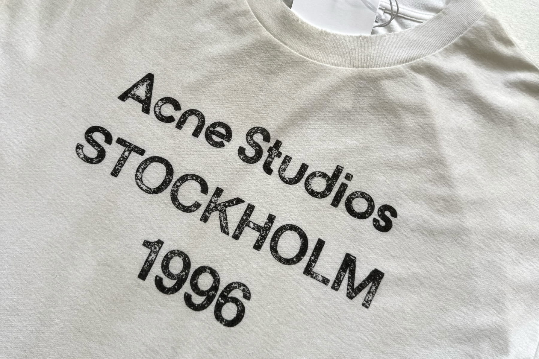 Acne Studios Stockholm 1996 print on a white t-shirt